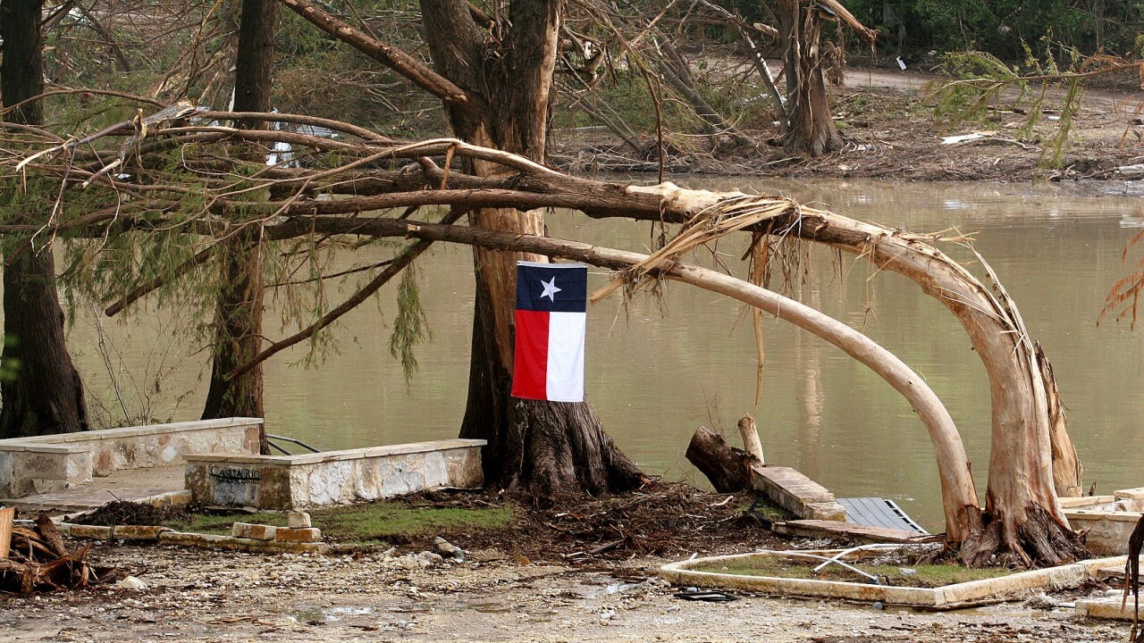 texas flag in front of flooded river